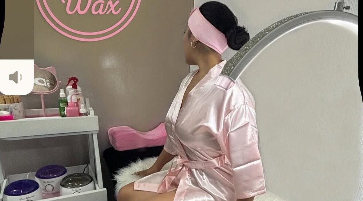 Cliente relajándose en Pinky Wax, Ciudad De México, MX con bata rosa en elegante cabina de estética.