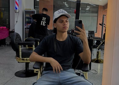 Interior moderno de Jonvthanbarber en Municipio Carrizal, Miranda, VE, con cliente en silla de barbero.