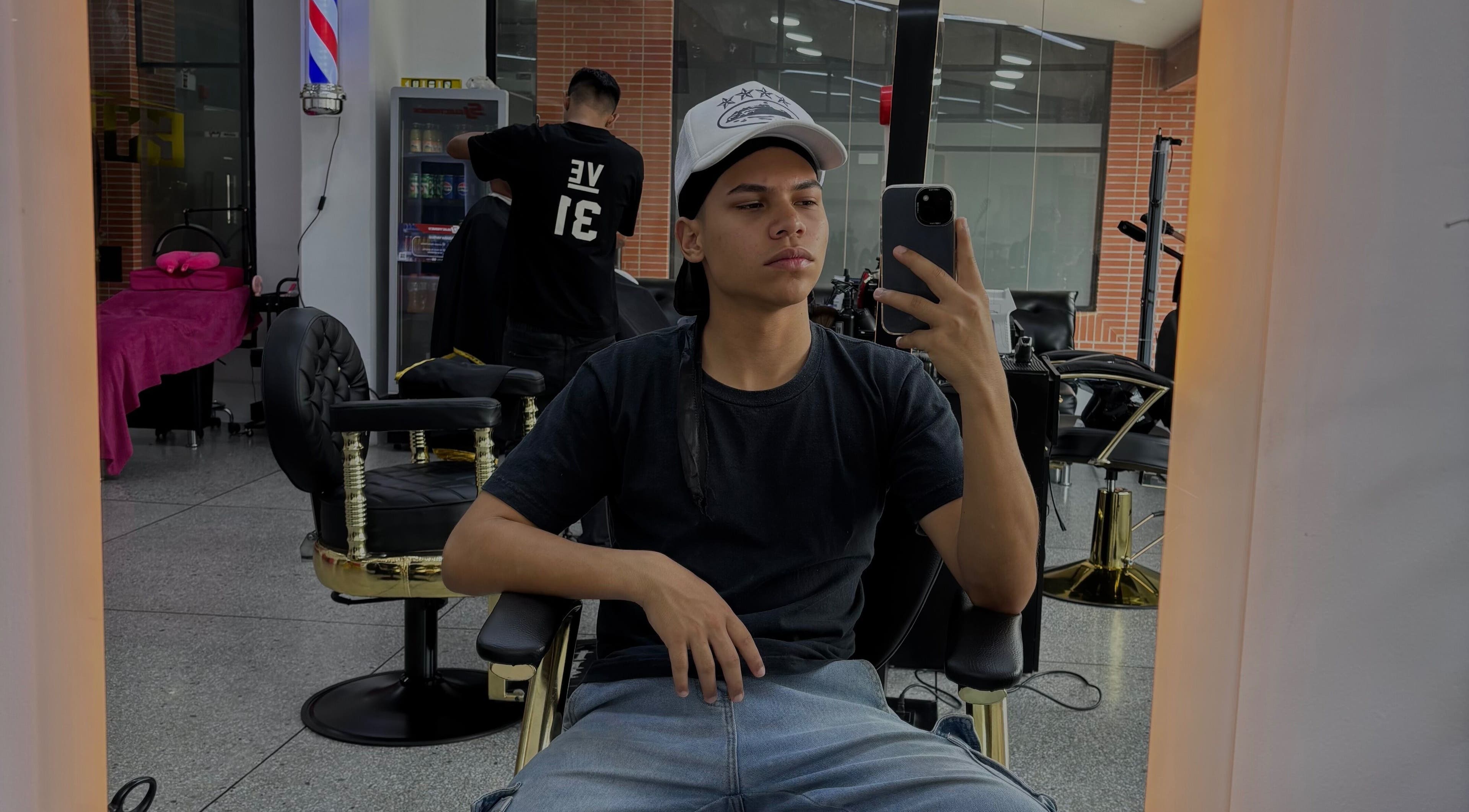 Cliente en Jonvthanbarber, Municipio Carrizal, Miranda, VE, sentado en silla de barbería tomando selfie.