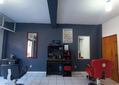Interior de FJ Barber, Manzanillo, Colima, MX, con sillas de peluquería y espejos.