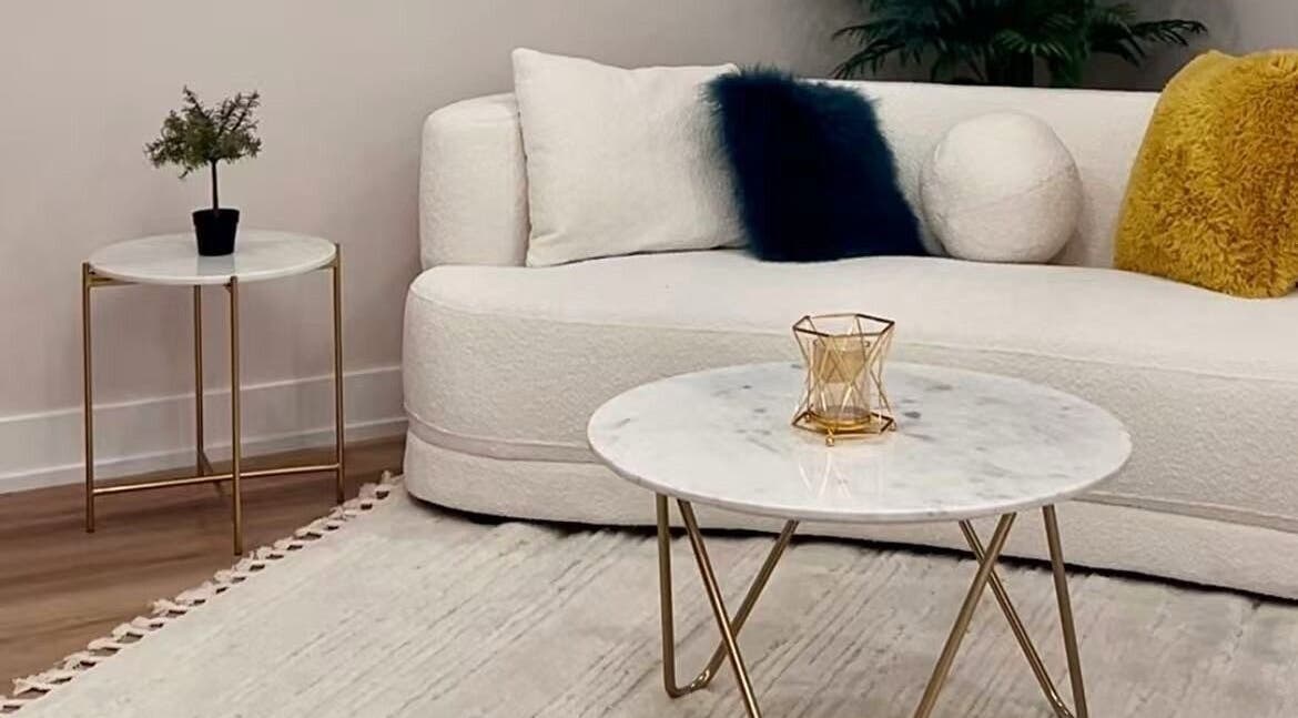 Sophisticated lounge area at LUMINA MEDI SPA, Mississauga, Ontario, CA, with plush sofa and marble tables.