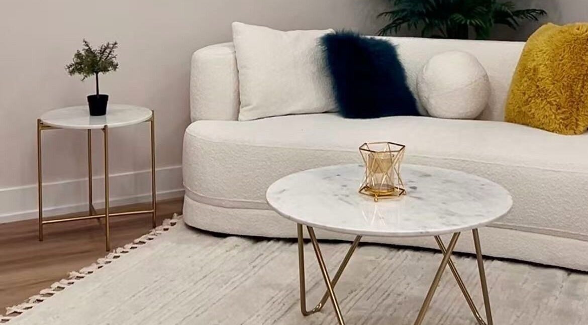 Sophisticated lounge area at LUMINA MEDI SPA, Mississauga, Ontario, CA, with plush sofa and marble tables.