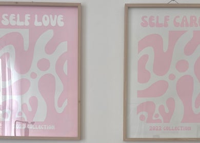 Pink framed art titled 'Self Love' and 'Self Care' at Through Her Eyes, Melbourne, Victoria, AU.