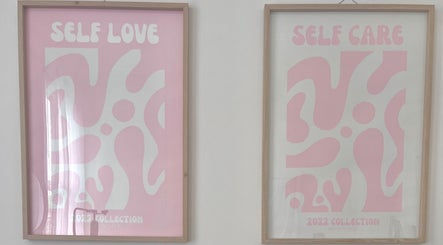 Pink framed art titled 'Self Love' and 'Self Care' at Through Her Eyes, Melbourne, Victoria, AU.