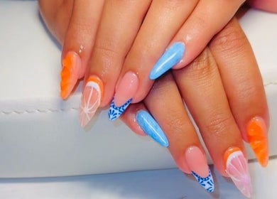 Bright and artistic nail art at Clawed & Cute, Michigan, Michigan, US; featuring orange and blue designs.