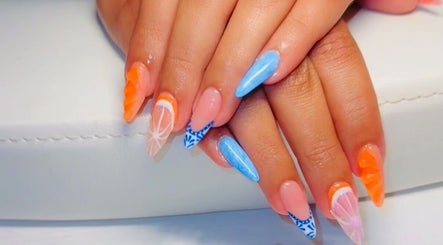 Bright and artistic nail art at Clawed & Cute, Michigan, Michigan, US; featuring orange and blue designs.