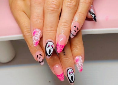 Intricate Halloween nail art at Clawed & Cute in Michigan, Michigan, US featuring ghostly designs and pink tips.