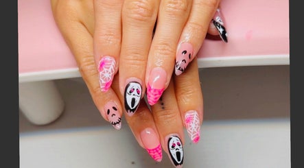 Intricate Halloween nail art at Clawed & Cute in Michigan, Michigan, US featuring ghostly designs and pink tips.