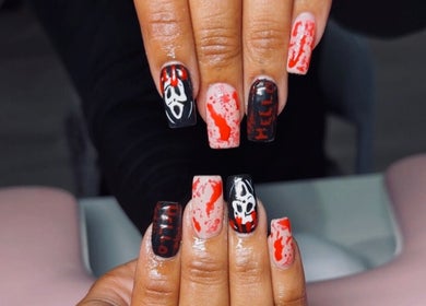 Halloween-themed nail art at Clawed & Cute, Michigan, US. Features ghostly designs with red accents.