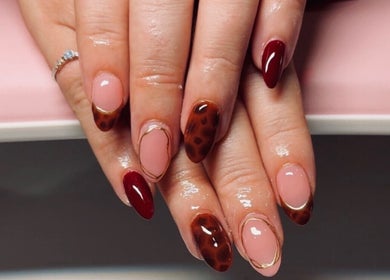 Chic nail art at Clawed & Cute in Michigan, Michigan, US with brown and pink tones.