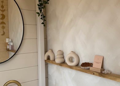 Elegant decor at Bonita By Kate, Hyde, England, GB, with unique vases and a round mirror on a calming wall.