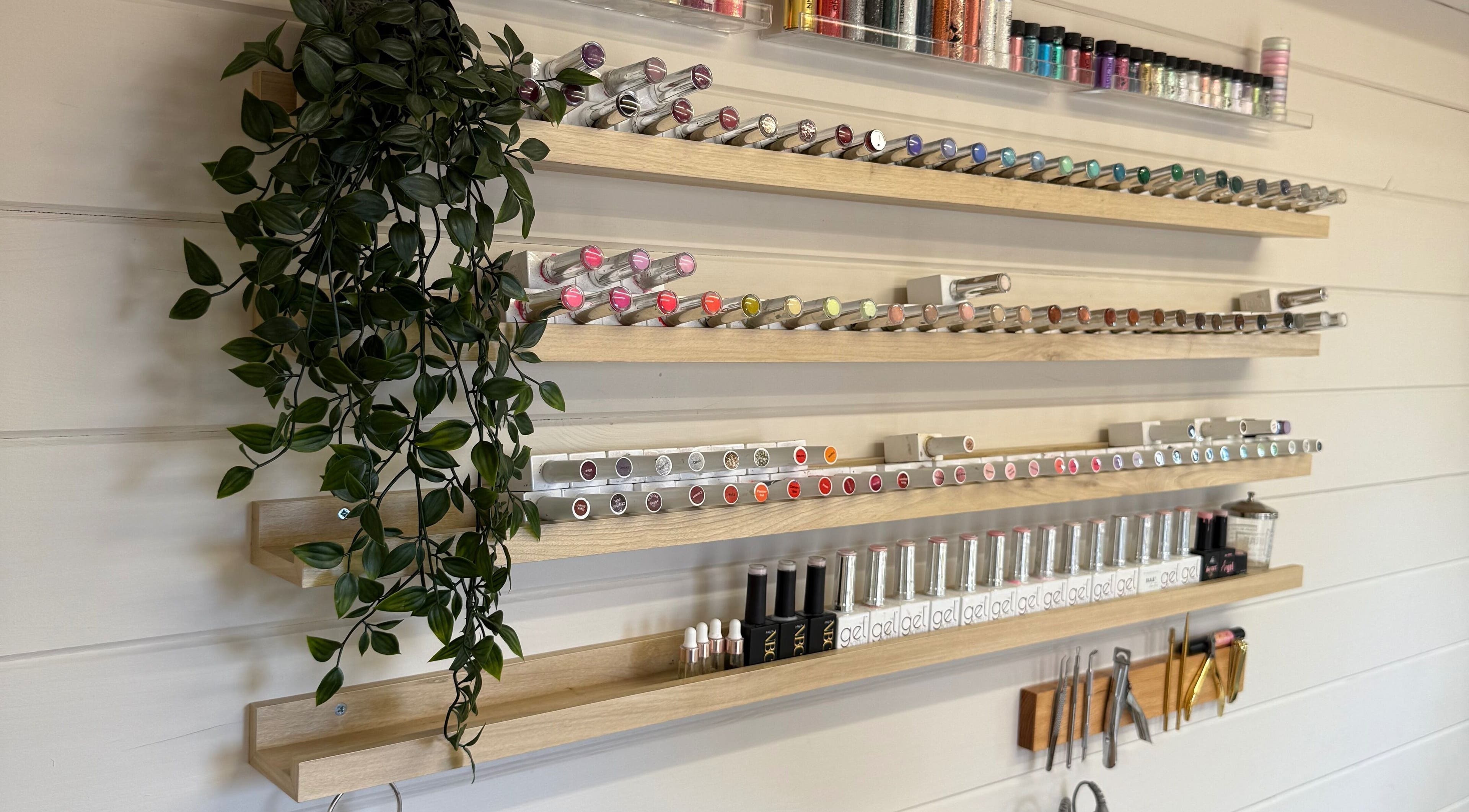 Bonita By Kate in Hyde, England, GB displays vibrant nail polish shelves adorned with greenery.
