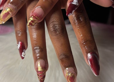 Elegant nail art in red and gold at Solembeauty in Labrador, Queensland, AU.