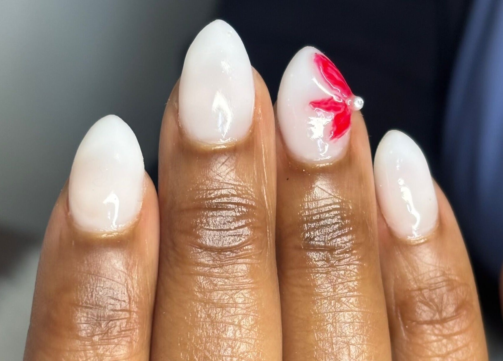 Stylish white nails with red flower design at Nail Diaries Studio, Sandton, Gauteng, ZA.