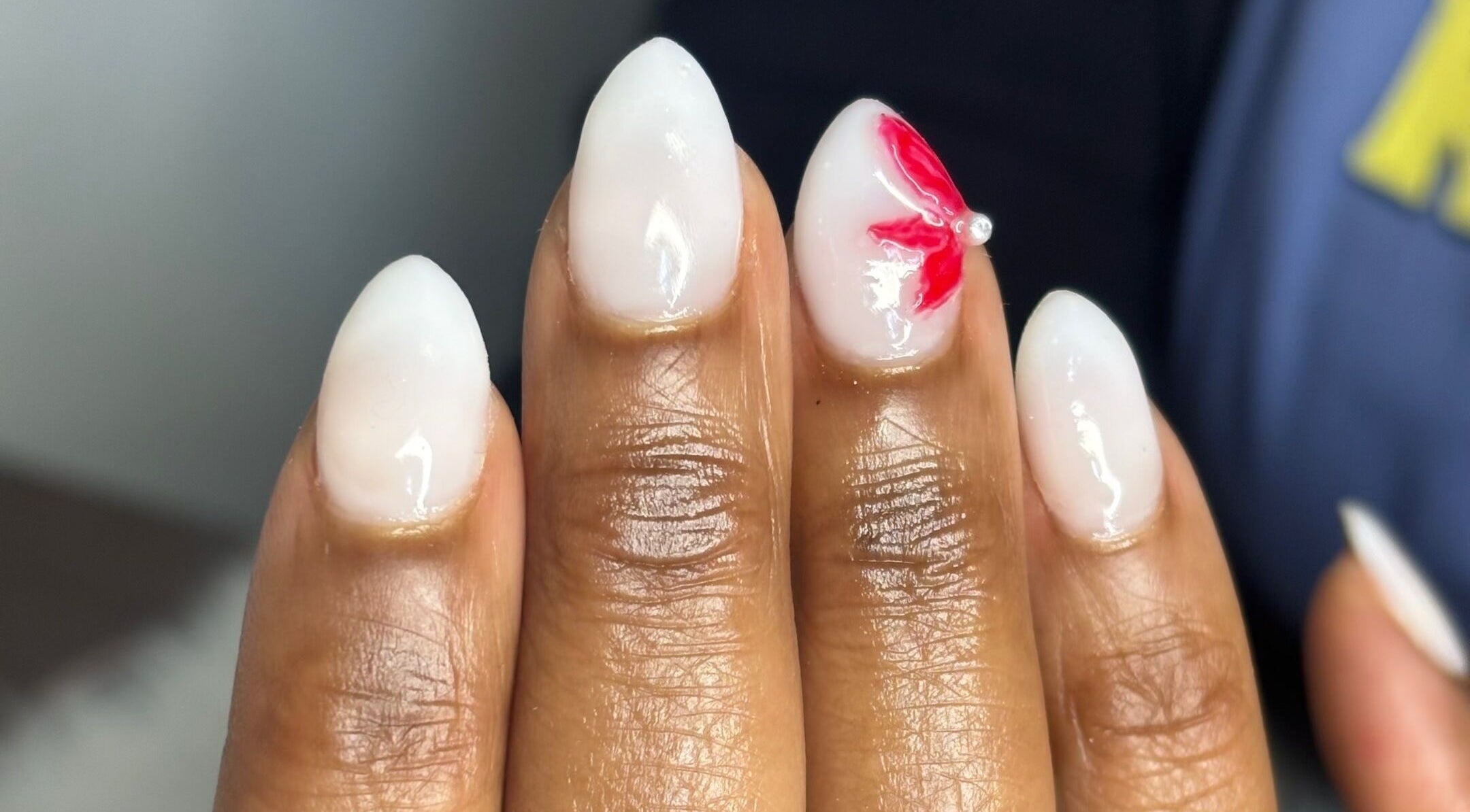 Stylish white nails with red flower design at Nail Diaries Studio, Sandton, Gauteng, ZA.