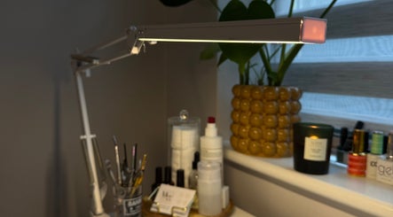 A well-lit beauty station at Mills Beauty, Oxenholme, England, GB with tools, products, and a vibrant plant.