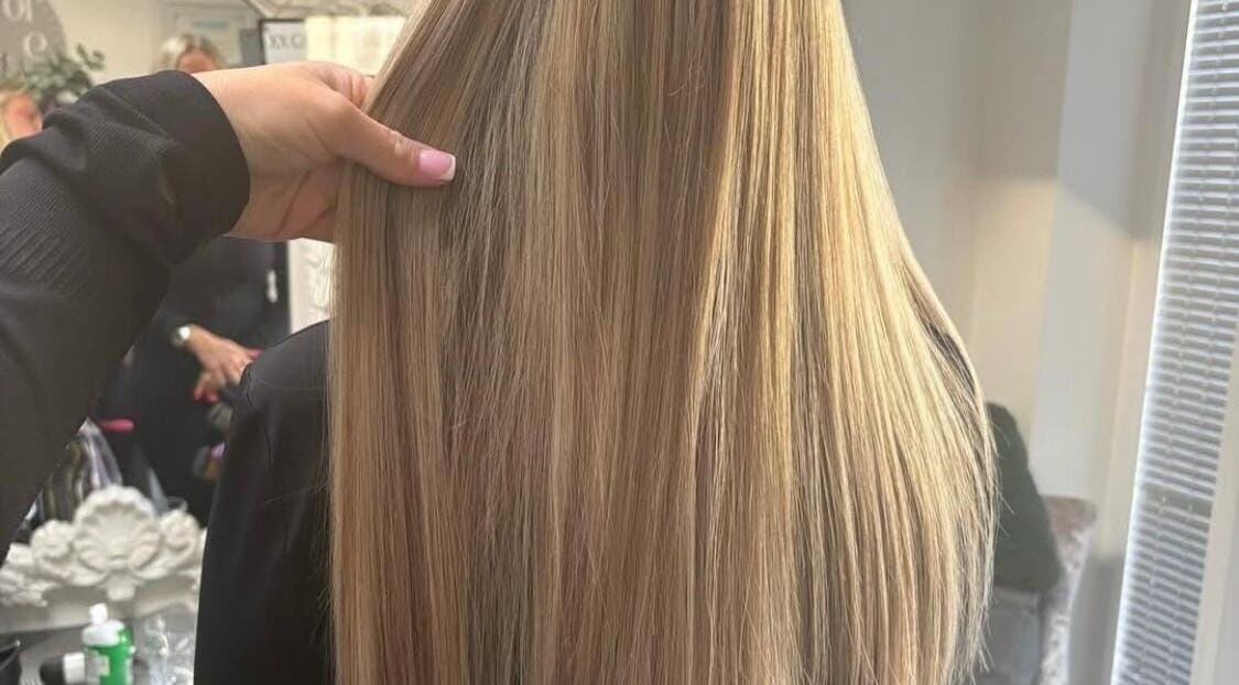 Smooth, blond hair styled at Hairbydlg in Dartford, GB, showcasing expert hairstyling in a bright salon.