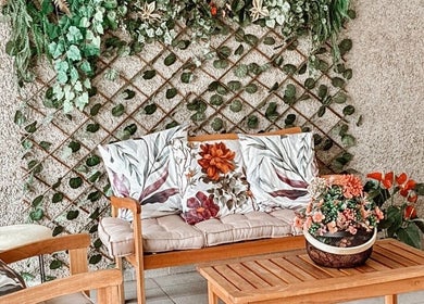 Área de descanso em Lu Delivery Spa, São Paulo, São Paulo, BR, com plantas e almofadas florais.