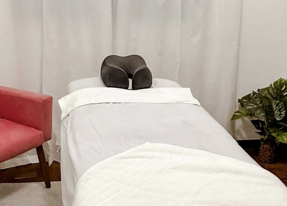 Sala de massagem no Lu Delivery Spa, São Paulo, São Paulo, BR, com cadeira rosa e decoração relaxante.