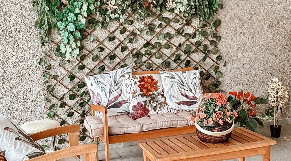 Área de descanso com sofá floral e plantas em Lu Delivery Spa, São Paulo, São Paulo, BR.