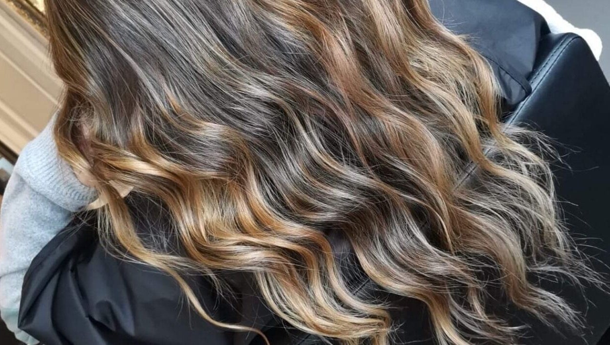 Wavy brown hair with highlights styled at Color Hub Salon, Cape Town, Western Cape, ZA.