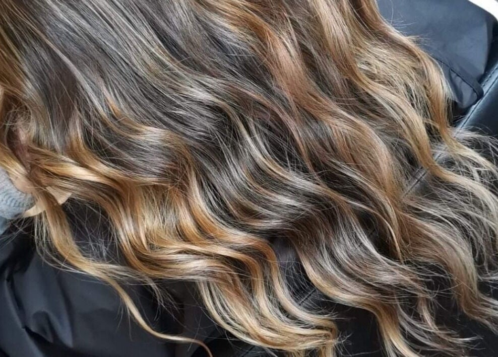 Wavy brown hair with highlights styled at Color Hub Salon, Cape Town, Western Cape, ZA.