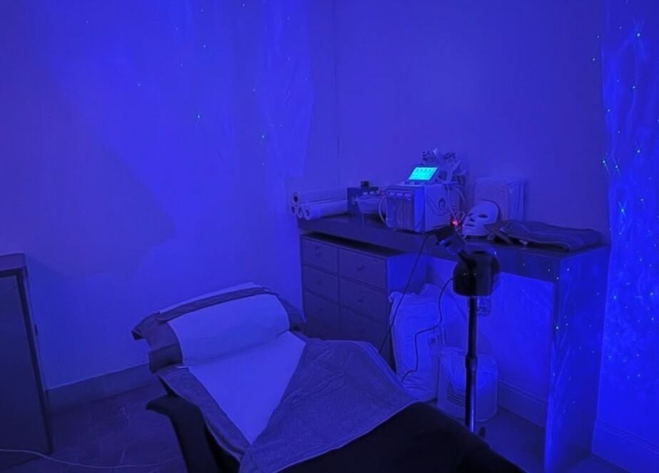 Dimly lit treatment room at PD Beauty Lounge, Bolton, England, GB featuring spa bed and equipment.