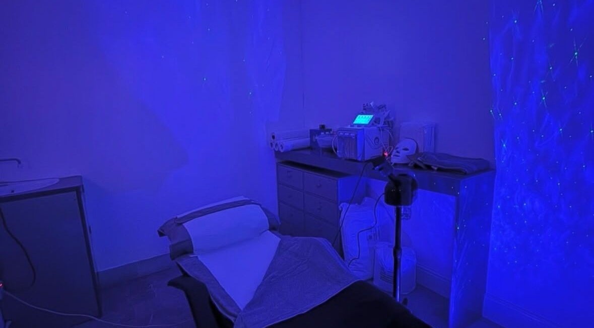 Dimly lit treatment room at PD Beauty Lounge, Bolton, England, GB featuring spa bed and equipment.