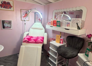 MK Beauty Hut, Coleraine features a stylish pink treatment room adorned with flowers and cozy decor.
