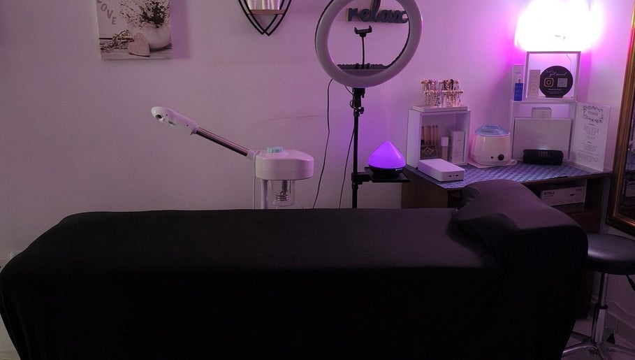Cozy treatment room at Beauty by Angie in Raħal Ġdid, MT, featuring ambient purple lighting and massage table.