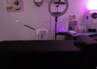 Cozy treatment room at Beauty by Angie in Raħal Ġdid, MT, featuring ambient purple lighting and massage table.