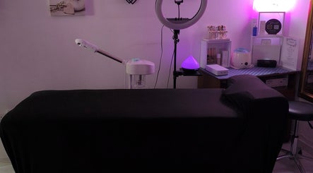 Cozy treatment room at Beauty by Angie in Raħal Ġdid, MT with black treatment bed and warm ambient lighting.