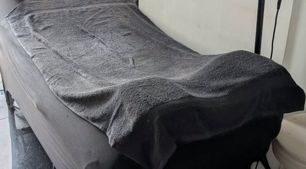 Table de massage avec serviette grise à Amandine Cils, Uchaud, Occitanie, FR, pour soins de bien-être.