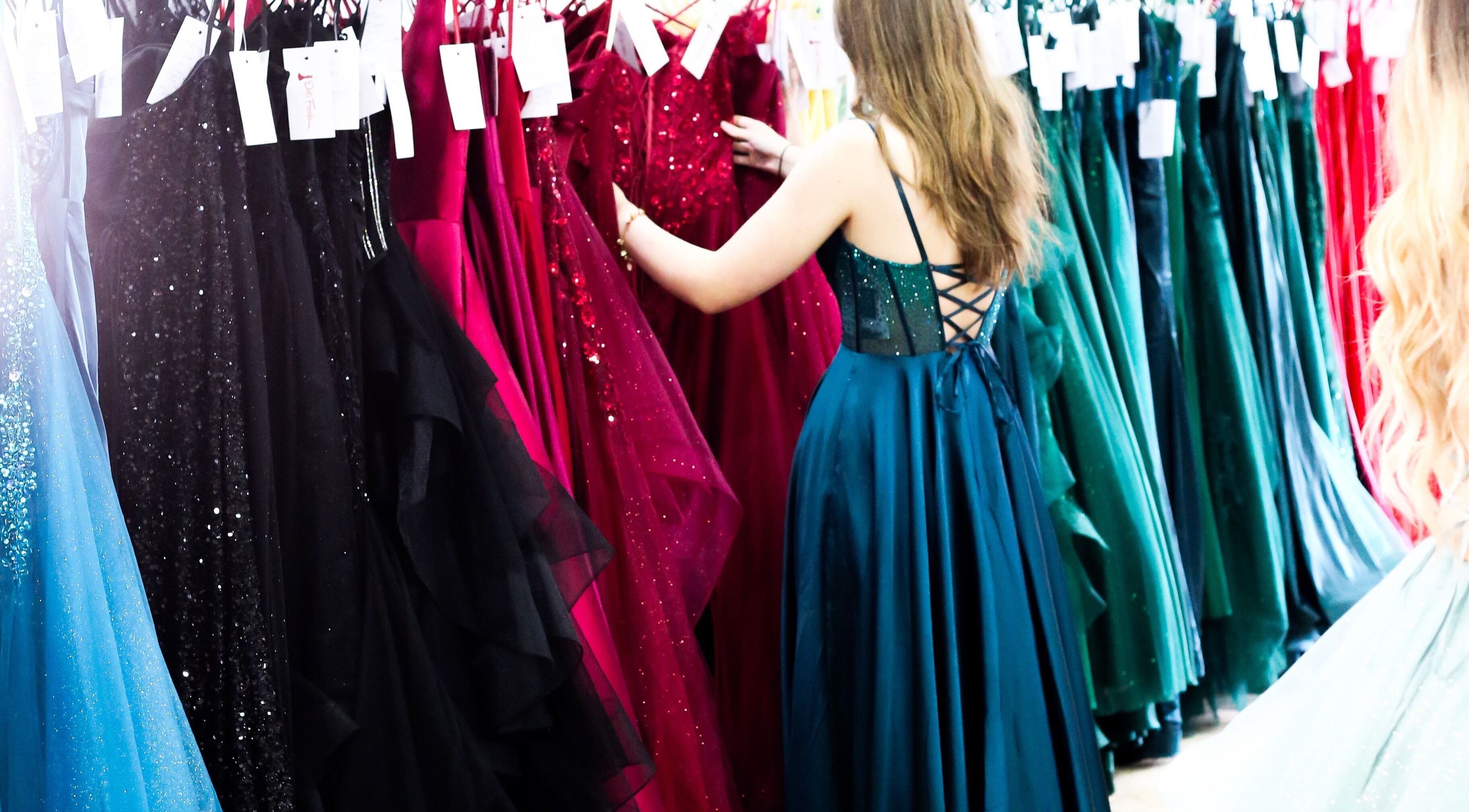 Shoppers browsing elegant gowns at Dot's Frocks, Manchester, England, GB for unique dress options.
