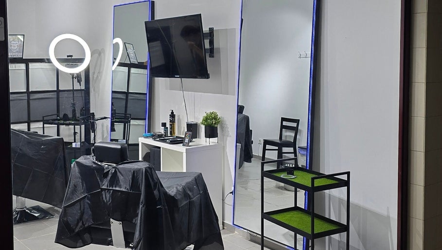 Interior moderno do Opog's Barbershop em Gaia, Porto, PT, destacando cadeira e espelho iluminado.
