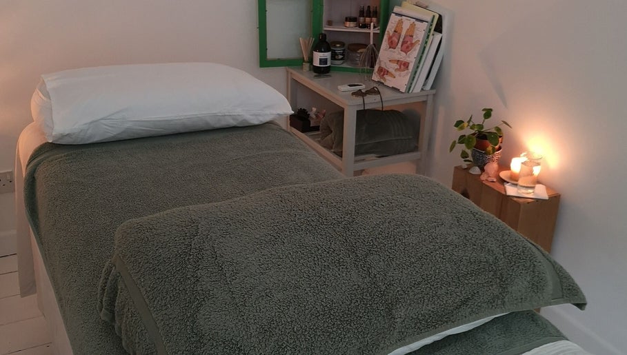 Calm therapy room at White Dove Holistic Therapies, Bideford, England, GB, with a cozy bed and candlelight.