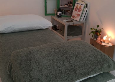 Calm therapy room at White Dove Holistic Therapies, Bideford, England, GB, with a cozy bed and candlelight.