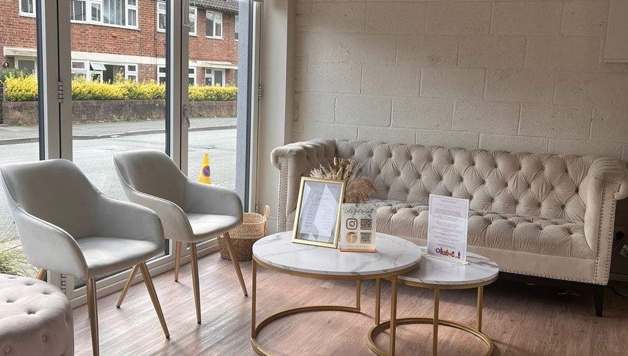 Elegant waiting area at Bronze Tanning Studio, Nantwich, England, GB with plush chairs and a sofa.