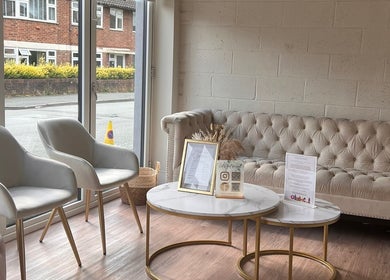 Elegant waiting area at Bronze Tanning Studio, Nantwich, England, GB with plush chairs and a sofa.