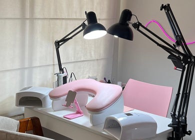 Estación de manicura en Amarte Studio, San Borja, Provincia De Lima, PE con lámparas y silla rosa.