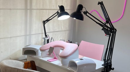 Estación de manicura en Amarte Studio, San Borja, Provincia De Lima, PE con lámparas y silla rosa.