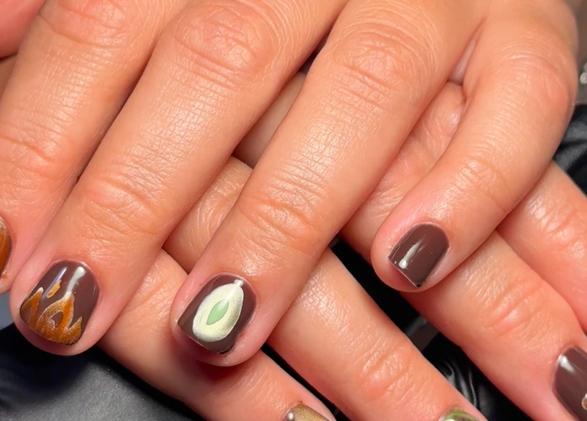 Close-up of artistic nail designs at My Nail Muse, Sheffield, England, GB showcasing brown and green accents.