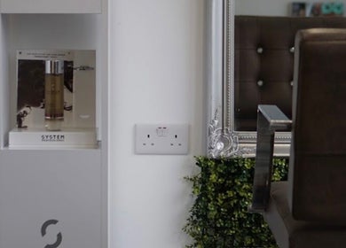 Elegant salon decor at Curly Life London, London, England, GB with stylish brown chair and product display.