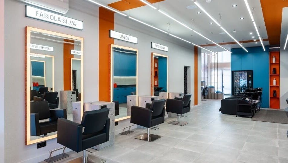 Interior elegante do salão Haroldo Jr. | Solo Concept em Lisboa, PT, com espelhos iluminados e cadeiras modernas.