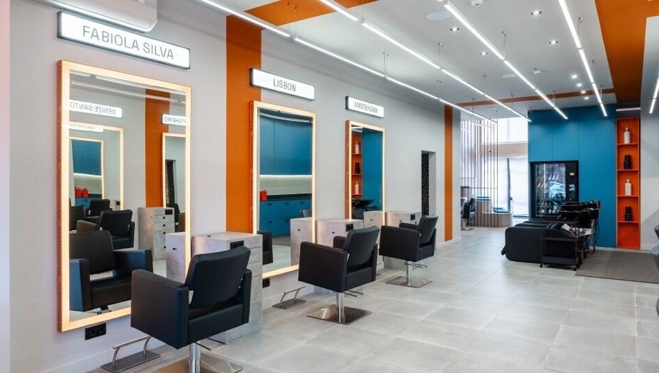 Interior elegante do salão Haroldo Jr. | Solo Concept em Lisboa, PT, com espelhos iluminados e cadeiras modernas.