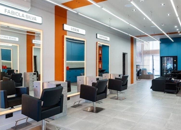 Interior elegante do salão Haroldo Jr. | Solo Concept em Lisboa, PT, com espelhos iluminados e cadeiras modernas.