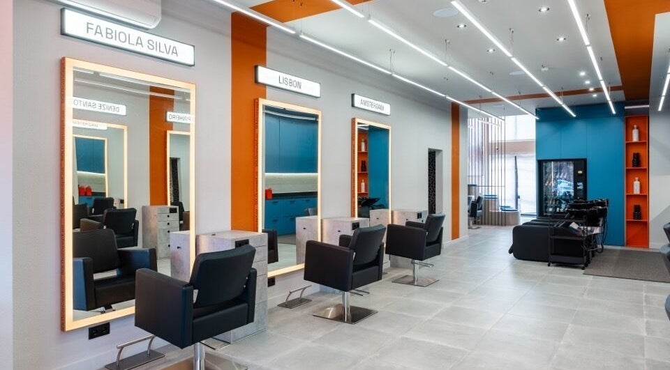 Interior elegante do salão Haroldo Jr. | Solo Concept em Lisboa, PT, com espelhos iluminados e cadeiras modernas.