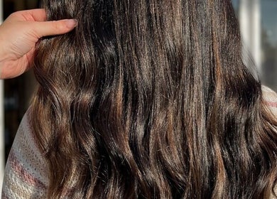 Detailed view of wavy, glossy brown hair at Hair by Micaela Rae, East Meadow, New York, US.