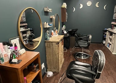 Modern salon interior at Hair by Micaela Rae in East Meadow, New York, US featuring chic mirrors and chairs.