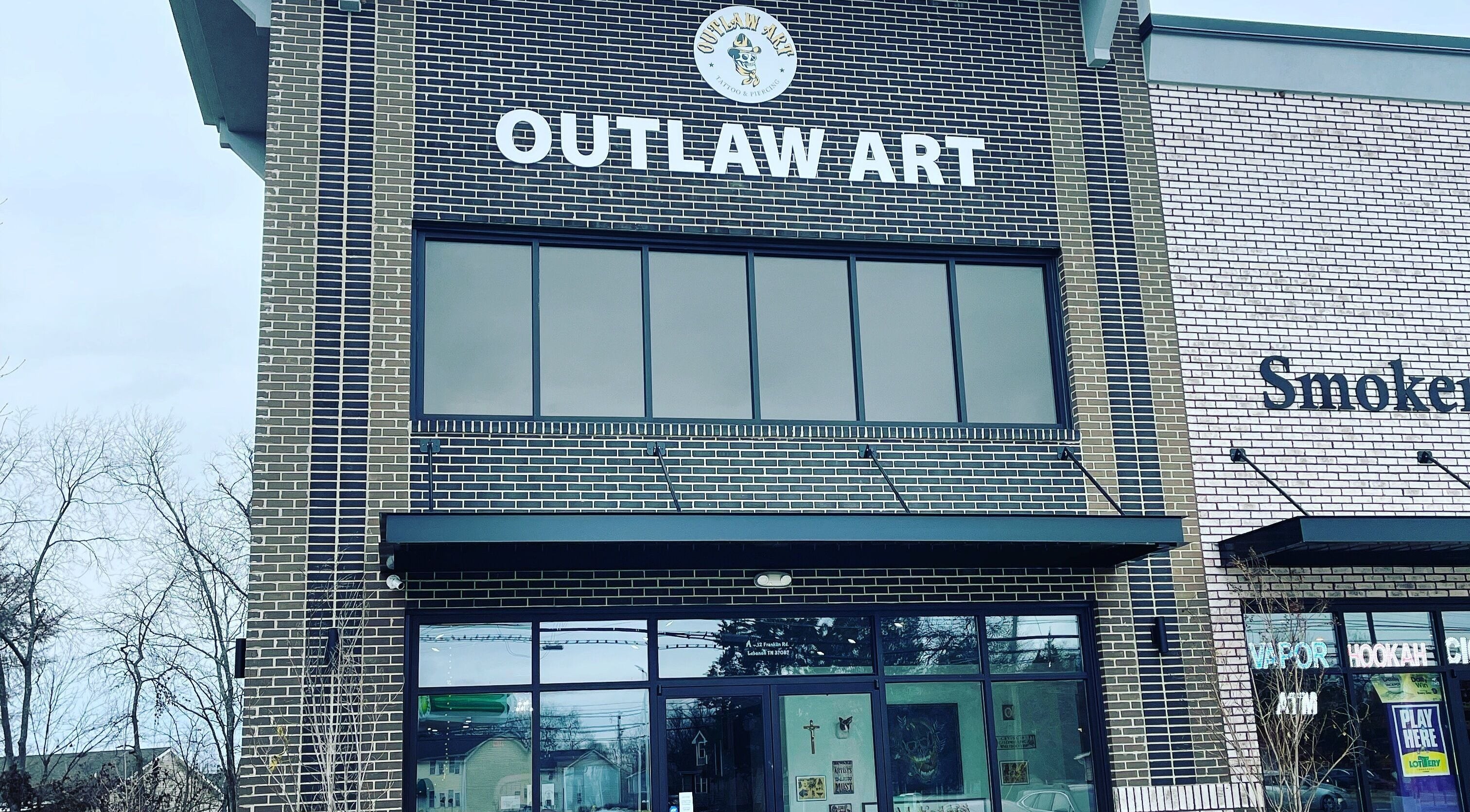 Front view of Outlaw Art Tattoo and Piercing in Lebanon, Tennessee, US showcasing its modern brick design.